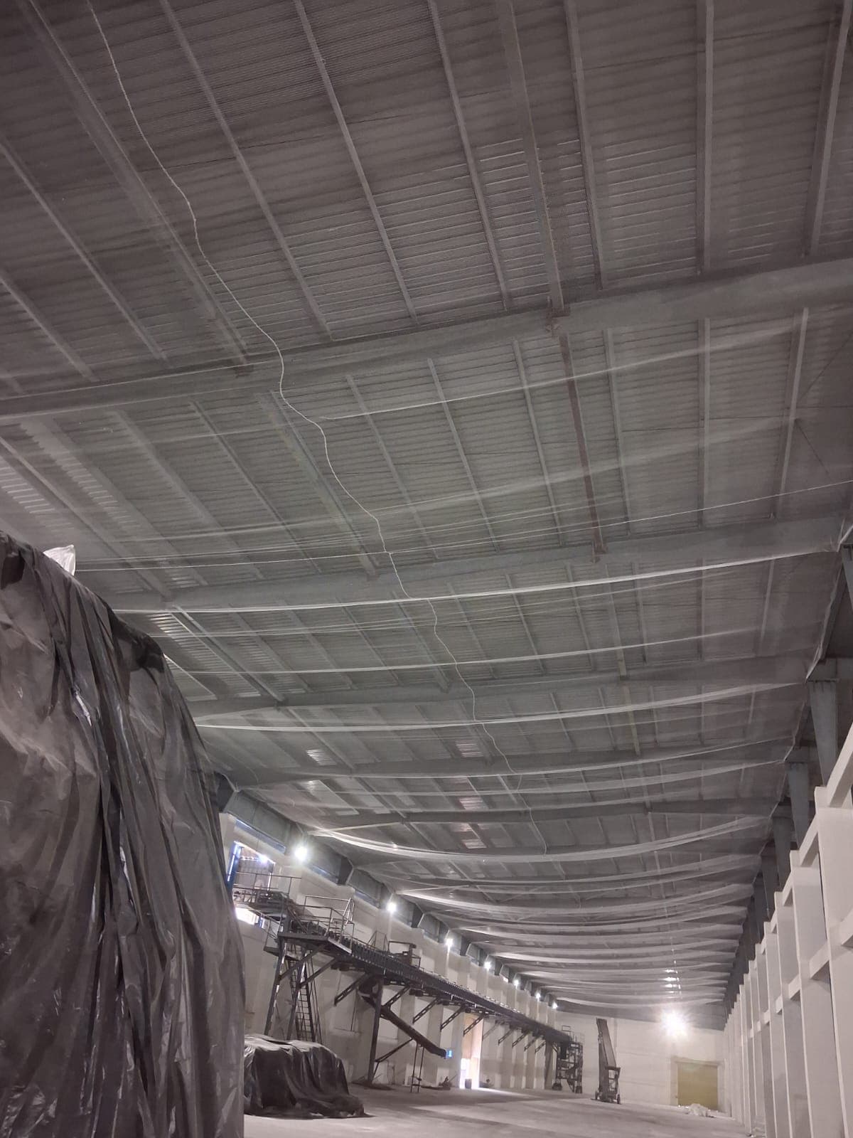Large warehouse interior with overhead mesh netting