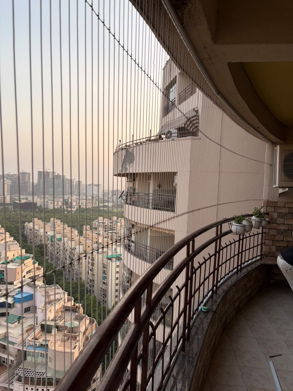Curved balcony invisible grill with city towers beyond
